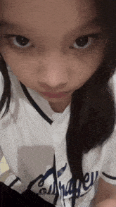 a girl wearing a la dodgers shirt looks at the camera
