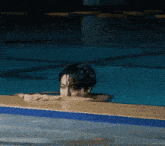 a man laying on the edge of a pool