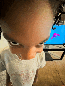 a young boy wearing a shirt that says ' snoop dogg ' on it looks at the camera