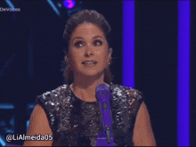 a woman in a sequined top is laughing in front of a purple microphone with the hashtag lialmeida05