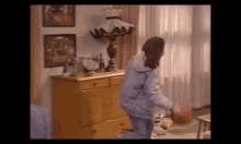 a woman is standing in a living room next to a lamp and dresser .