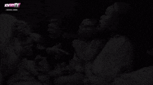 a black and white photo of a group of women sitting on a couch with the word now on the bottom right