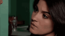a close up of a woman 's face with a man behind her