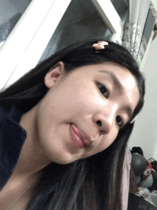 a girl with a pink flower in her hair is making a funny face