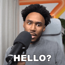 a man sitting in front of a microphone with the words hello on his face
