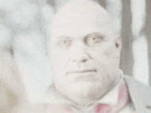 a blurry picture of a bald man with a red tie