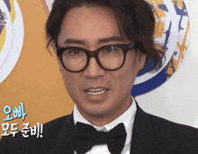 a man wearing glasses and a bow tie has a foreign language behind him