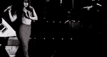 a woman is standing on a stage in front of a microphone .