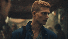 a man with red hair is standing in a crowded area