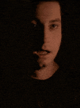 a close up of a man 's face in the dark with his mouth open