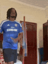 a man in a blue samsung shirt is dancing in a room