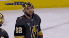 a hockey player wearing a number 22 jersey stands on the ice