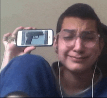a man is taking a picture of himself with a gun on his phone