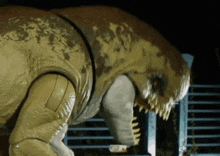 a close up of a toy dinosaur with sharp teeth standing in front of a fence .