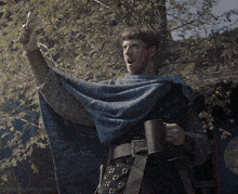 a man in a blue cape is holding a sword and a mug with the words lord-aldhelm gifs visible below him