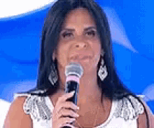 a woman is holding a microphone in front of her face .
