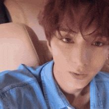 a close up of a man 's face with a blue shirt on