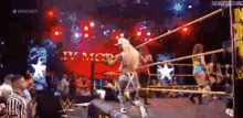 a wrestling match is going on in a ring with a referee