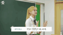 a girl is standing in front of a blackboard in a classroom .