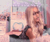 a woman wearing glasses is laying on a bed with a sign that says love you baby