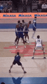 a volleyball game is being played in front of a mikasa ad