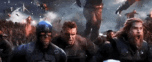 captain america , hulk , thor and black widow are standing in front of a crowd .