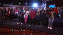 a group of young men are dancing in front of a projector that says ellentube