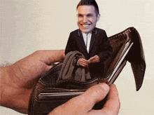 a person is holding a wallet with a picture of a man in it