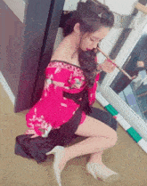 a woman in a red kimono is kneeling down on the floor