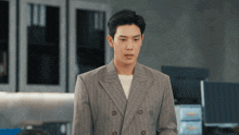 a man in a striped suit is standing in front of a computer