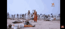 a man in a red robe stands in front of a group of people laying on the ground