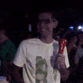 a man wearing glasses is holding a red object