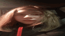 a close up of a woman 's face with a red ribbon in her hair