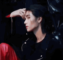 a man wearing a black jacket and red pants is looking at the camera