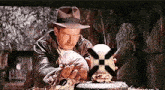 a man in a hat is holding a ball in his hands .