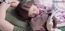 a man and a woman are laying on top of each other and smiling .