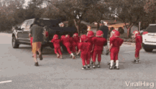 a group of children wearing red football uniforms and helmets