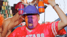 a man wearing a red shirt that says ' stade ' on the front