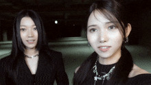 two women are standing next to each other and one is wearing a necklace that says " i love you "