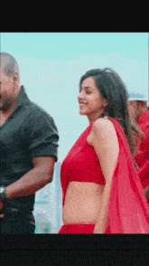 a woman in a red crop top is dancing with a man .