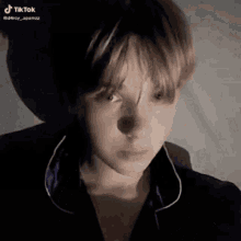 a close up of a young boy 's face in a dark room wearing pajamas .
