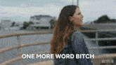 a woman walking across a bridge with the words one more word bitch written on the bottom