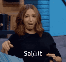 a woman is sitting on a couch with her mouth open and the word sahit written on her chest