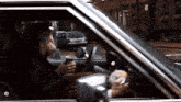 a man drinking a cup of coffee while driving a car