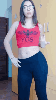 a woman wearing glasses and a red top that says yo8