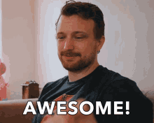 a man sitting on a couch with the words awesome written on the screen