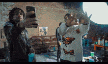 a man in a butterfly sweater takes a selfie
