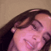 a close up of a woman 's face with a pink headband on her head .