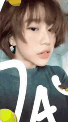 a girl with short hair is wearing a shirt that says ta