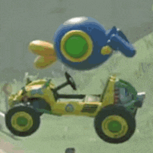 a toy car with a blue balloon on top of it is flying through the air .